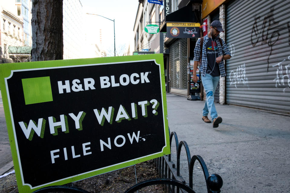 A man walks past an advertisement for H&R Block in the Brooklyn borough of New York City. Tax returns in the United States are due to the government on April 18. (Credit: Drew Angerer, Getty Images)