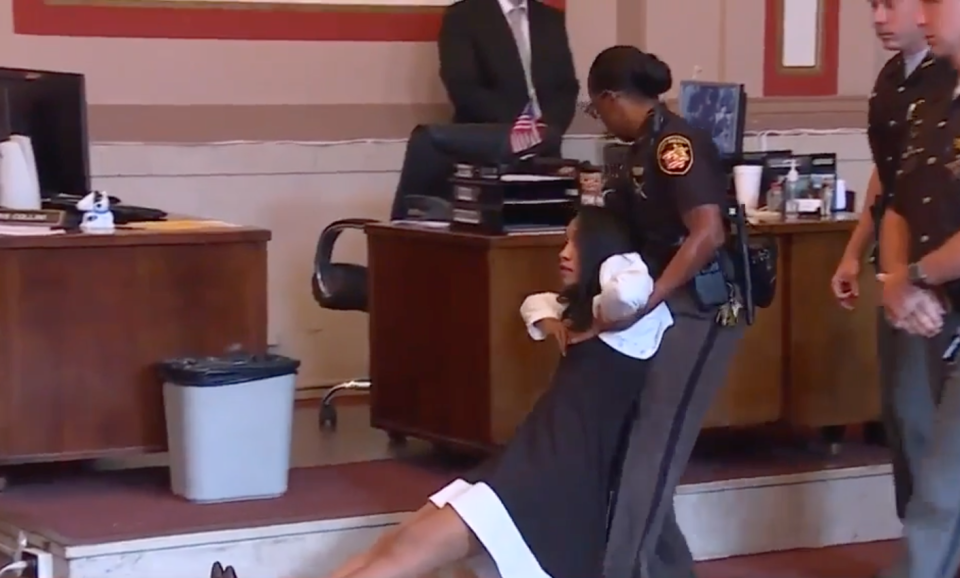 Photo of former judge Tracie Hunter being dragged from court after being convicted for illegally helping her brother keep his job. 