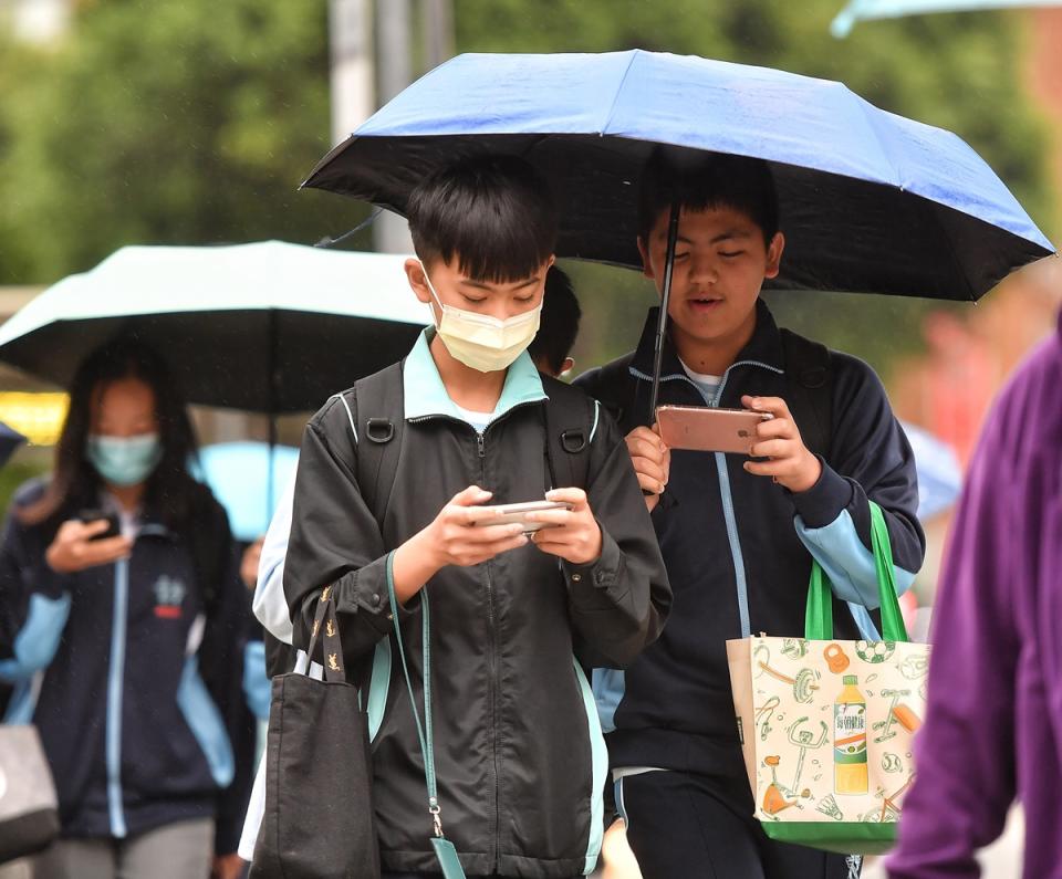 北部變天，雨傘出現。（中央社）