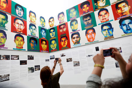 Journalists are seen in front of portraits of the 43 missing Ayotzinapa College Raul Isidro Burgos students during a press preview of the exhibition "Restablecer Memorias" by Chinese artist Ai Weiwei, displayed at the University Museum of Contemporary Art (MUAC) in Mexico City, Mexico, April 11, 2019. REUTERS/Edgard Garrido/Files