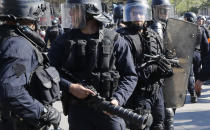 Police form a security line at the Place de Republique during a yellow vest demonstration in Paris, Saturday, April 20, 2019. French yellow vest protesters are marching anew to remind the government that rebuilding the fire-ravaged Notre Dame Cathedral isn't the only problem the nation needs to solve. (AP Photo/Michel Euler)