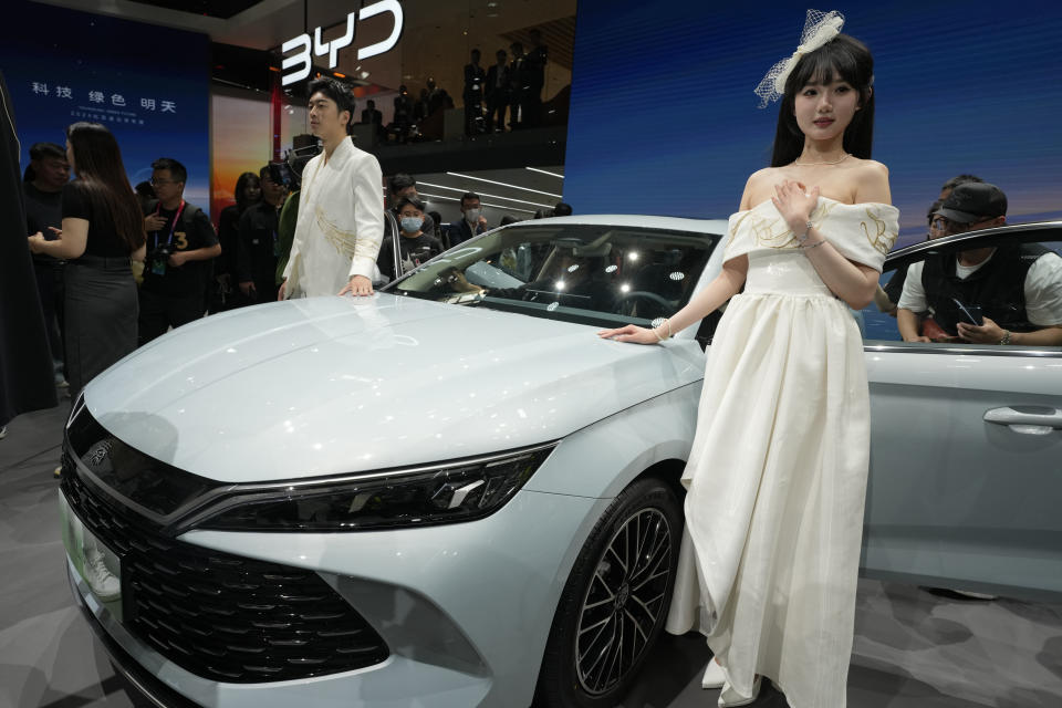 Models pose near the BYD Qin L Dmi unveiled during Auto China 2024 held in Beijing, Thursday, April 25, 2024. China's largest EV maker, BYD has been expanding rapidly into overseas markets, launching its low-priced Dolphin Mini, sold as the Seagull in China, in Latin American markets this year. (AP Photo/Ng Han Guan)