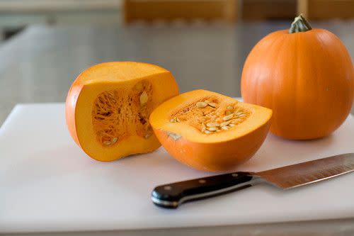 Pumpkin on cutting board with knife