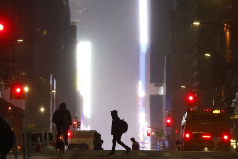 Pedestrians cross Seventh Avenue as snow falls in New York City on Tuesday. New York's Central Park got 1 inch of snow since midnight and 1.4 inches fell in the last day, putting an end to an over two year snow drought streak. Photo by John Angelillo/UPI