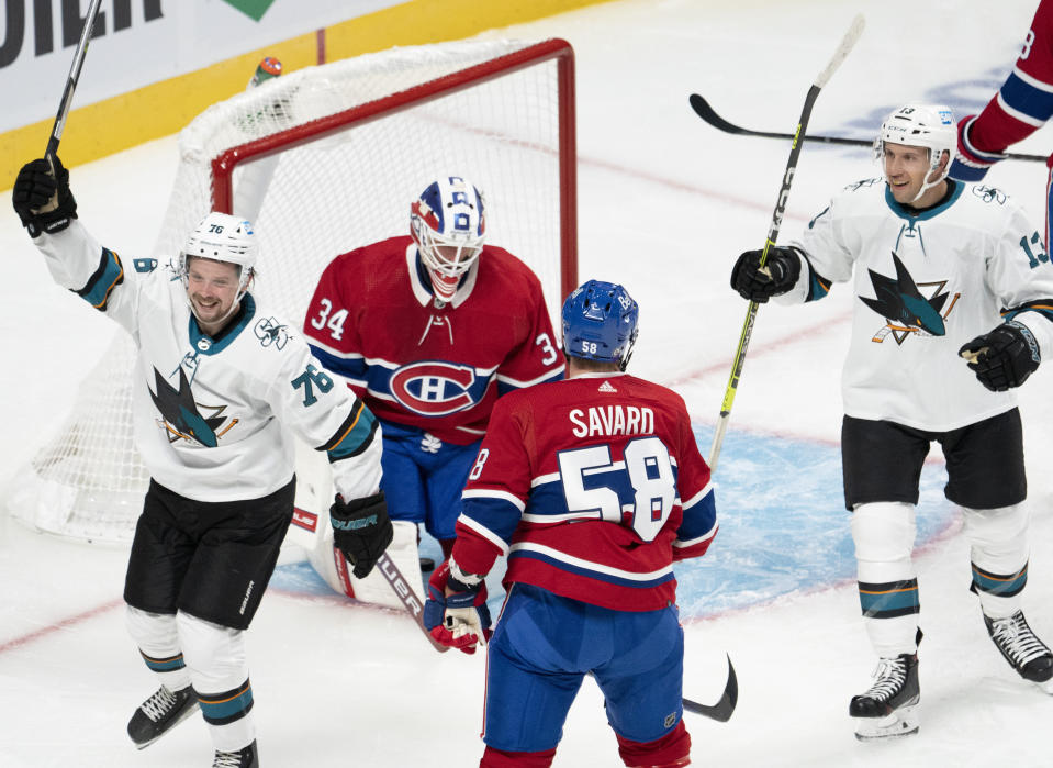 San Jose Sharks' Jonathan Dahlen (76) and Nick Bonino (13) celebrate a goal against Montreal Canadiens goaltender Jake Allen (34), as Canadiens' David Savard (58) watches during the second period of an NHL hockey game Tuesday, Oct. 19, 2021, in Montreal. (Ryan Remiorz/The Canadian Press via AP)