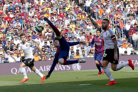 Barcelona's Lionel Messi (L) controls the ball against Valencia's player Nicolas Otamendi during their Spanish first division soccer match at Nou Camp stadium in Barcelona April 18, 2015. REUTERS/Gustau Nacarino