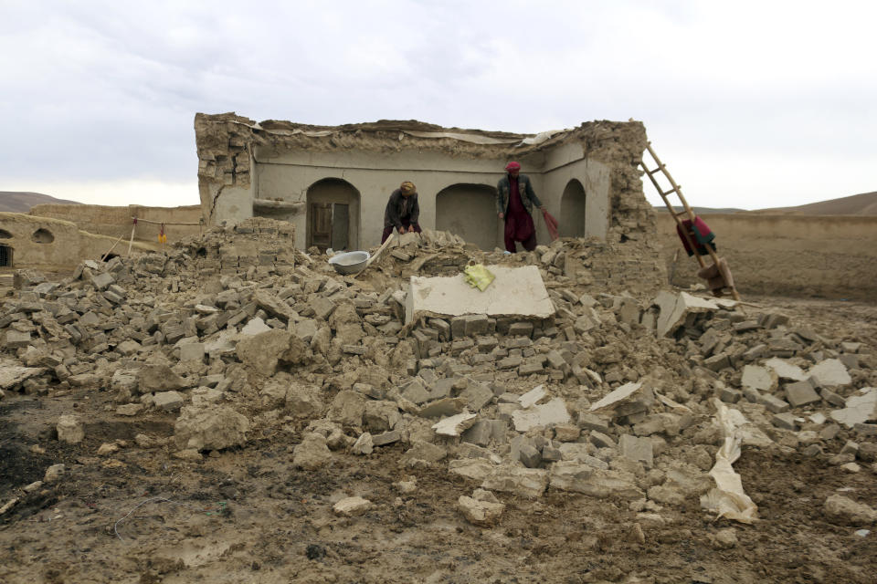 Afghan villagers remove bricks after their home was damaged by Monday's earthquake the remote western province of Badghis, Afghanistan, Tuesday, Jan. 18, 2022. The United Nations on Tuesday raised the death toll from Monday's twin earthquakes in western Afghanistan, saying three villages of around 800 houses were flattened by the temblors. (Abdul Raziq Saddiqi)