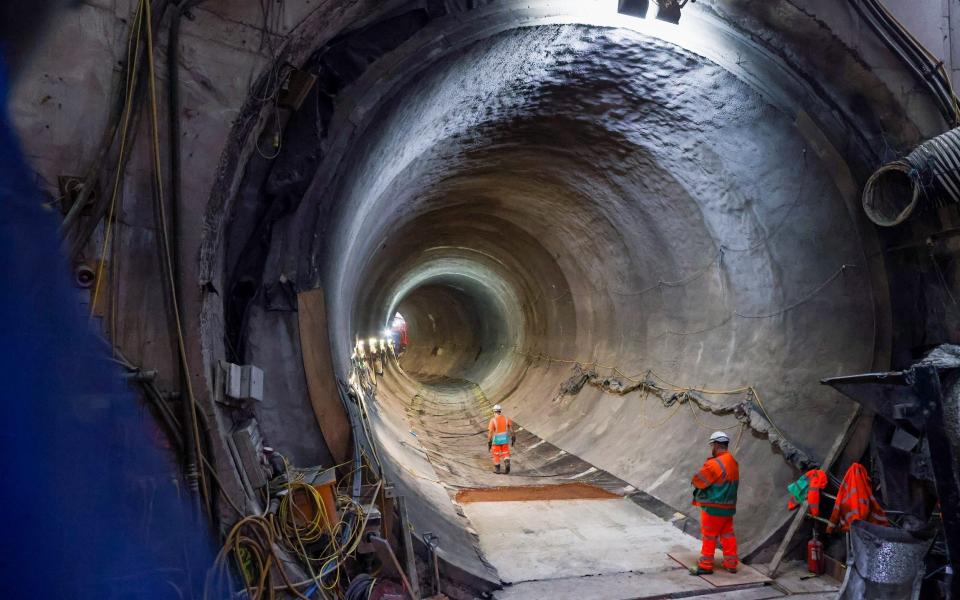 Construction workers walking through the main section of the Thames Tideway tunnel, which is still under construction