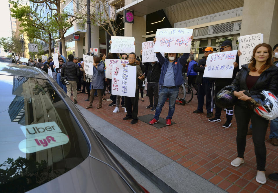 FILE - In this May 8, 2019,, file photo, Uber and Lyft drivers carry signs during a demonstration outside of Uber headquarters in San Francisco. Companies like Uber and Lyft helped create the so-called gig economy. Legislation pending in the Assembly could set a clearer standard for who, exactly, is an independent contractor with a "gig" and who has the rights of a full-fledged employee. Backed by labor unions, the bill, AB5, could expand rights and benefits to workers now labeled independent contractors, in turn upending some industries. (AP Photo/Eric Risberg, File)