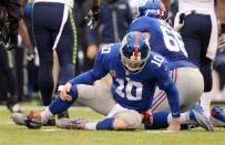Dec 15, 2013; East Rutherford, NJ, USA; New York Giants quarterback Eli Manning (10) sits on the ground after being sacked by the Seattle Seahawks during the second half at MetLife Stadium. Mandatory Credit: Joe Camporeale-USA TODAY Sports
