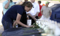 <p>A woman pauses at a table with 10 candles, roses and bibles displayed during a prayer vigil following a deadly shooting at Santa Fe High School in Santa Fe, Texas, on Friday, May 18, 2018. (Photo: David J. Phillip/AP) </p>