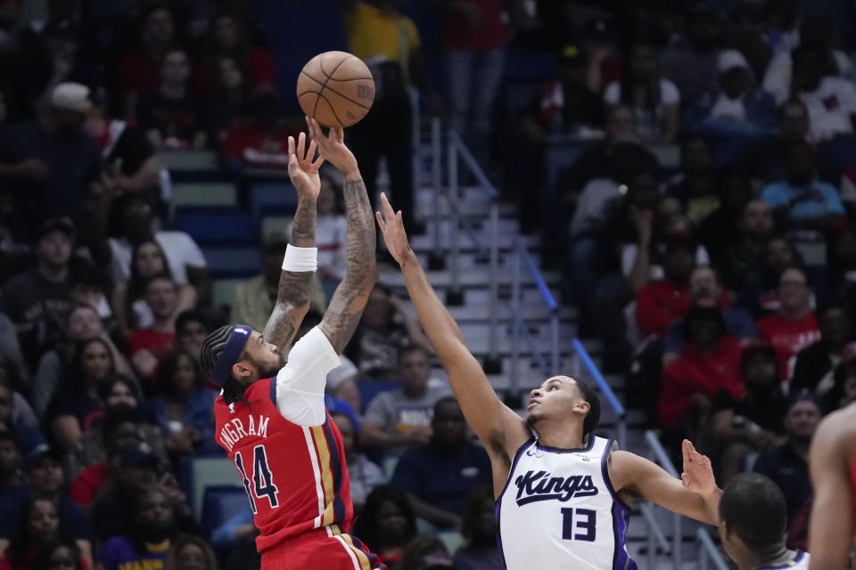 New Orleans Pelicans forward Brandon Ingram (14) shoots against Sacramento Kings forward Keegan Murray (13) in the first half of an NBA basketball play-in tournament game in New Orleans, Friday, April 19, 2024. (AP Photo/Gerald Herbert)