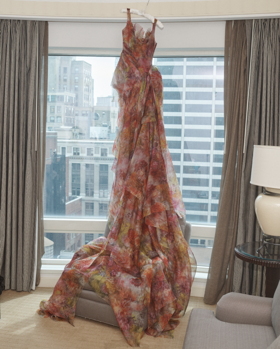 a woman wearing a floral dress in a hotel suite