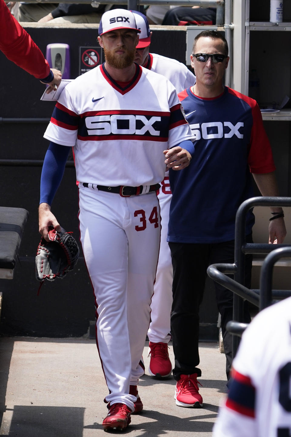 Chicago White Sox starting pitcher Michael Kopech, left, walks in the dugout with a team trainer after being injured during the first inning of a baseball game against the Texas Rangers in Chicago, Sunday, June 12, 2022. (AP Photo/Nam Y. Huh)