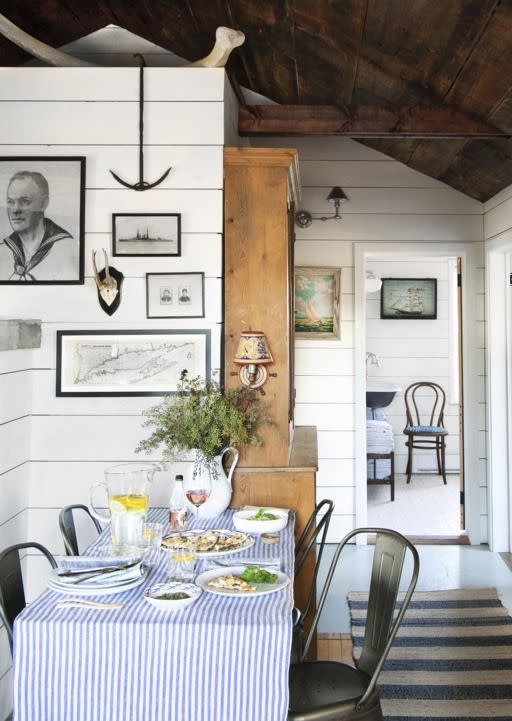 <p>A small bistro table set in a hallway creates a mini makeshift dining room. Bright white shiplap painted with a coat of <a href="https://www.benjaminmoore.com/en-us/color-overview/find-your-color/color/cc-30/oxford-white?color=CC-30" rel="nofollow noopener" target="_blank" data-ylk="slk:Oxford White by Benjamin Moore;elm:context_link;itc:0;sec:content-canvas" class="link ">Oxford White by Benjamin Moore</a> makes the ceilings of these tiny quarters soar.</p>