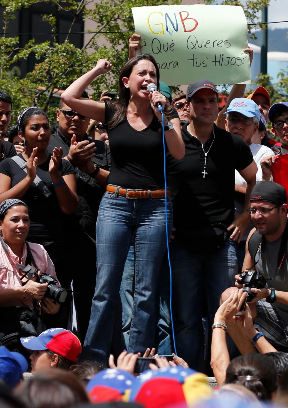Opposition Congresswoman Maria Corina Machado speaks to protesters in Caracas, Venezuela, Saturday, Feb. 15, 2014. Demonstrators are protesting the Wednesday killings of two university students who were shot in different incidents after an anti-government protest demanding the release of student protesters arrested in various parts of the country. The sign behind reads in Spanish "Bolivarian National Guard, what do you want for your children?" (AP Photo/Fernando Llano)