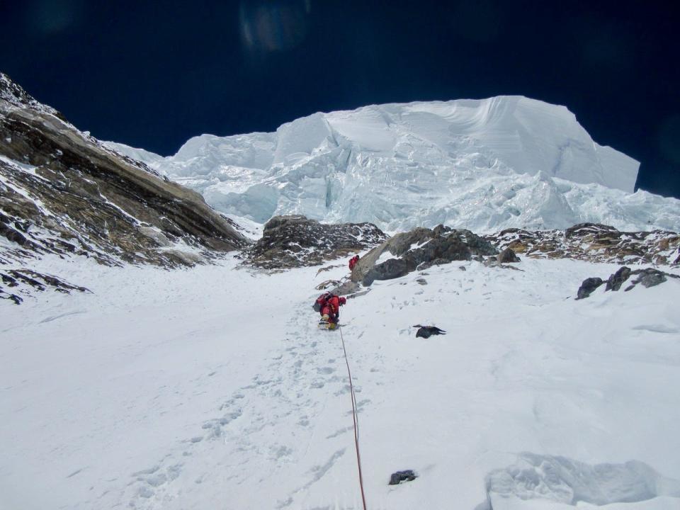 Climbers approach the Bottleneck and the traverse in 2014, as a giant ice cliff hangs over them.