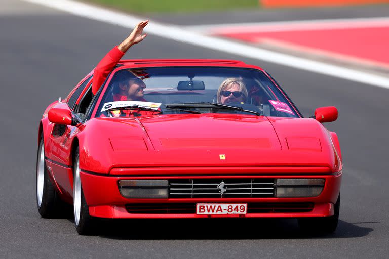 Carlos Sainz saluda durante el desfile de conductores previo al Gran Premio, a bordo de una Ferrari