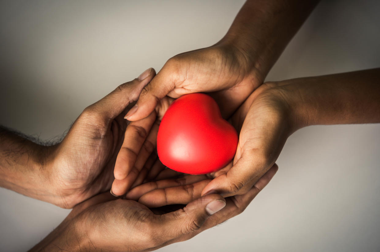 Helping hand of heart donor for patient in heart disease. Man give red heart to woman as couple. People lifestyle and couple romance. Healthcare and hospital medical concept. Symbolic of Valentine day