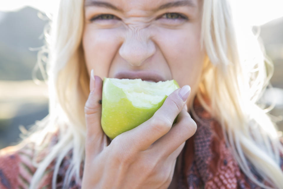 person biting into an apple