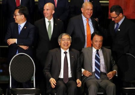 Japan's Minister of Finance Taro Aso and Bank of Japan (BOJ) Governor Haruhiko Kuroda sit in front of South Korean Finance Minister Kim Dong-yeon, Mexico's Secretary of Finance Jose Antonio Gonzalez Anaya, Organisation for Economic Co-operation and Development (OECD) Secretary-General Angel Gurria and Brazil's Finance Minister Eduardo Guardia before posing for the official photo at the G20 Meeting of Finance Ministers in Buenos Aires, Argentina, July 21, 2018. REUTERS/Marcos Brindicci