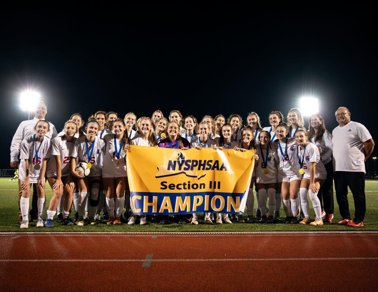 New Hartford players pose with their championship banner after defeating Westhill 3-2 Friday.