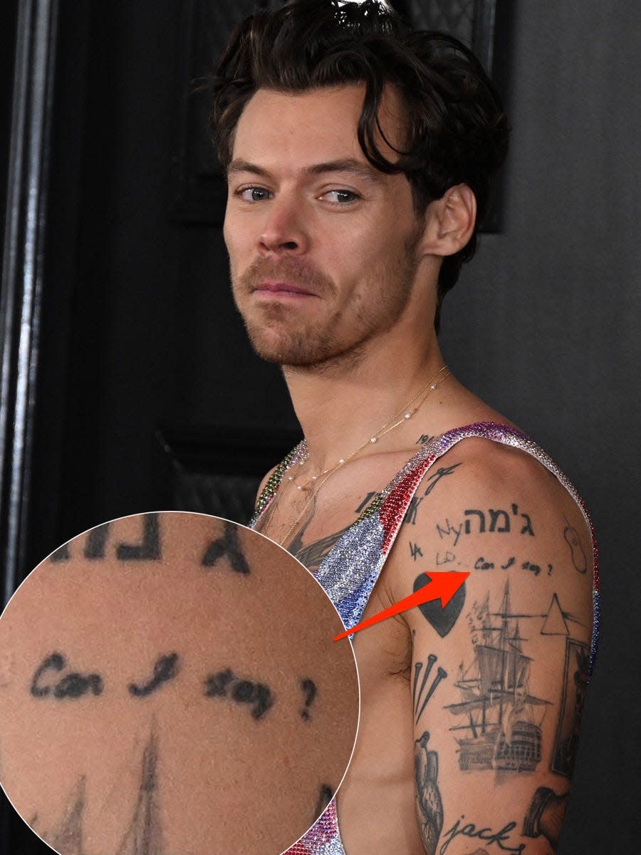 A red arrow pointing to a tattoo of the phrase "Can I stay?" on Harry Styles' left arm.