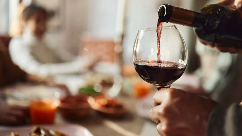 pouring red wine into a glass