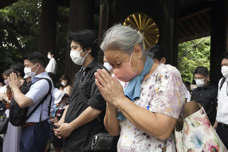 Visitors observe a minute of silence for paying respects to the war dead at Yasukuni Shrine Monday, Aug. 15, 2022, in Tokyo. Japan marked the 77th anniversary of its World War II defeat Monday. (AP Photo/Eugene Hoshiko)