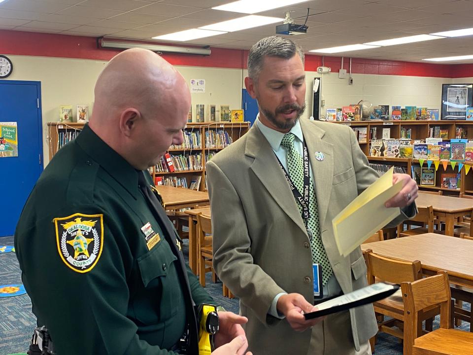 Okaloosa County School District Safe Schools Specialist Danny Dean presents Okaloosa County Sheriff's Office School Resource Officer Deputy Jeramy Dobkins with a Certificate of Commendation. Dobkins was recognized for his "profound innovation" in creating a QR code that helps students discretely access Fortify Florida, an anonymous reporting tool.