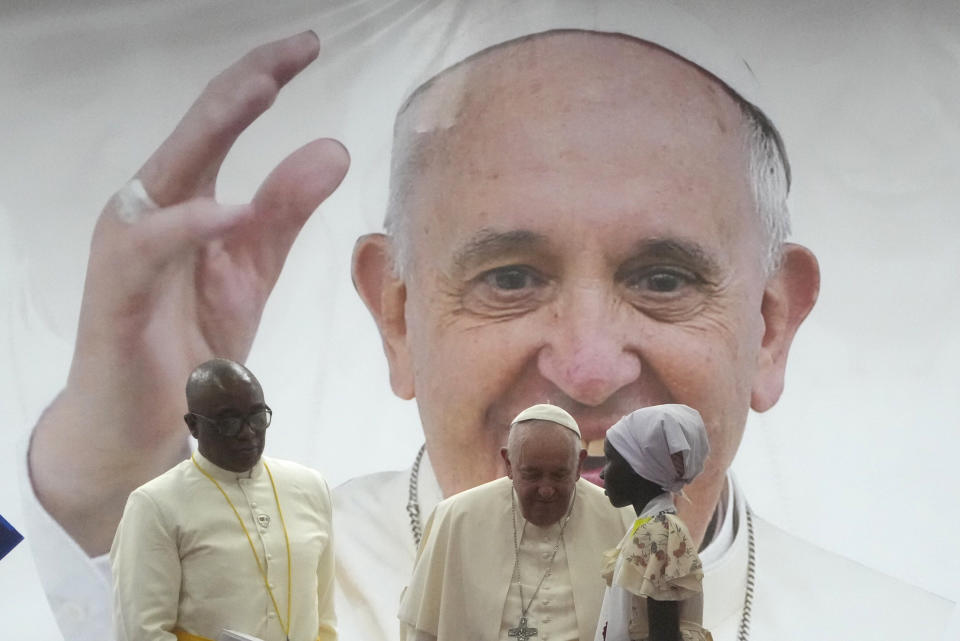 Pope Francis meets a displaced girl during a meeting with internally displaced persons in the "Freedom Hall" in Juba, South Sudan, Saturday, Feb. 4, 2023. Francis is in South Sudan on the second leg of a six-day trip that started in Congo, hoping to bring comfort and encouragement to two countries that have been riven by poverty, conflicts and what he calls a "colonialist mentality" that has exploited Africa for centuries. (AP Photo/Gregorio Borgia)