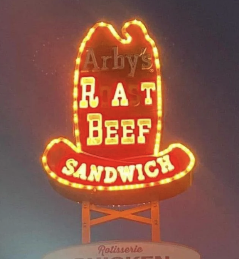 An Arby's sign with some letters unlit reads "RAT BEEF SANDWICH" instead of the full brand name and product