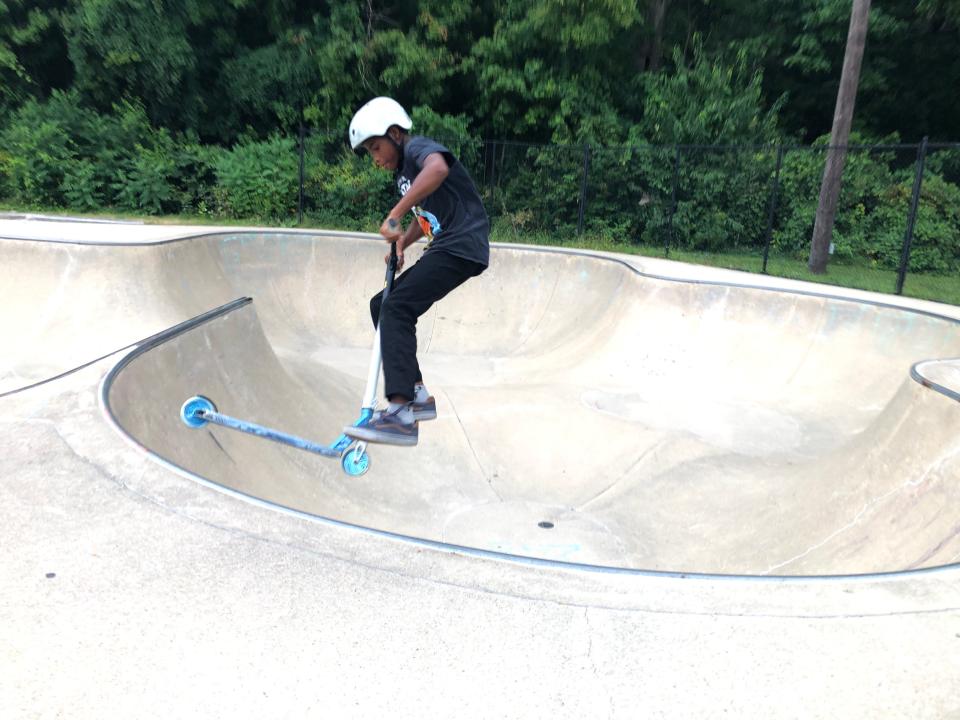 Xzavier Long, 11, flips his scooter over the bowl of the O'Brien Skate Park in South Bend on Sept. 8. 2023.