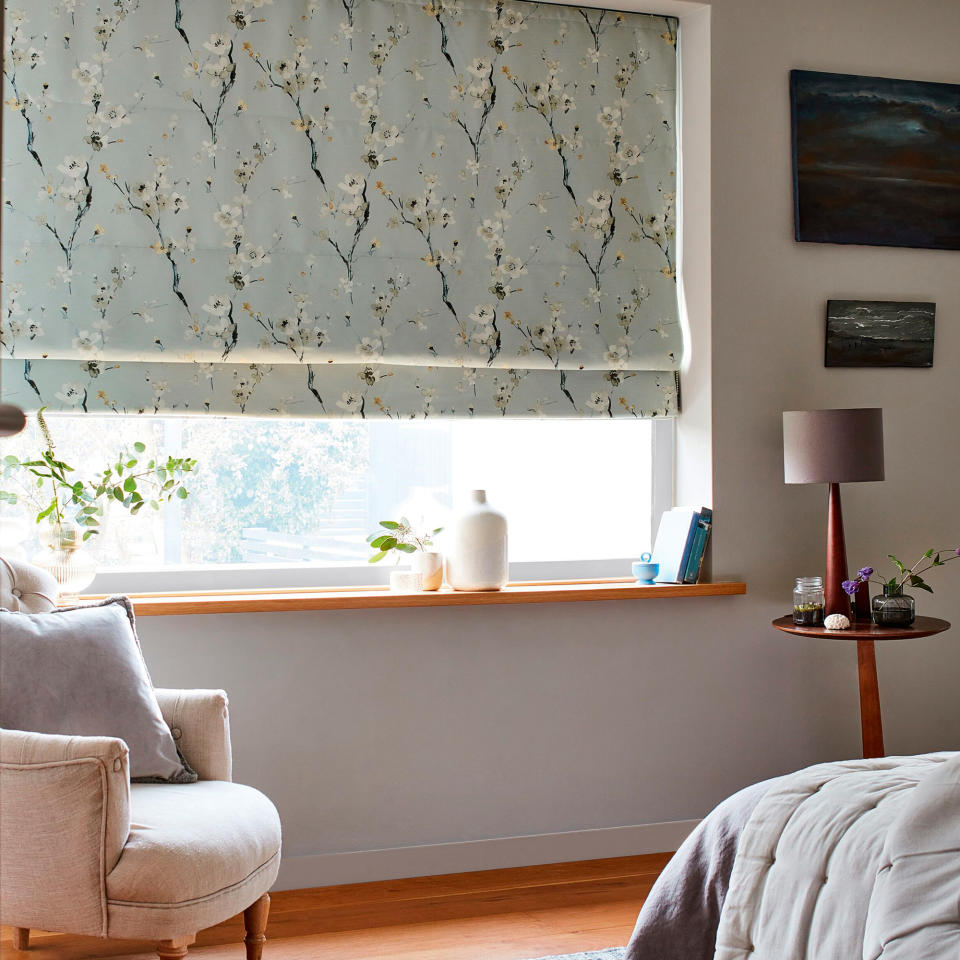 Pale duck egg blind with a cherry blossom design at a living room window