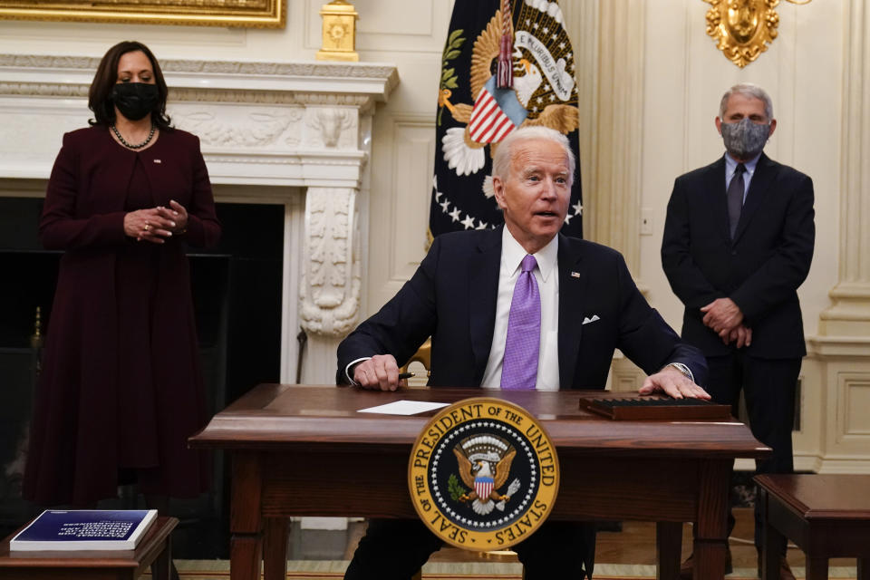 FILE - In this Jan. 21, 2021, file photo, President Joe Biden reacts to a reporters question after signing executive orders in the State Dinning Room of the White House, in Washington. Vice President Kamala Harris, left, and Dr. Anthony Fauci, director of the National Institute of Allergy and Infectious Diseases, right, look on. (AP Photo/Alex Brandon, File)