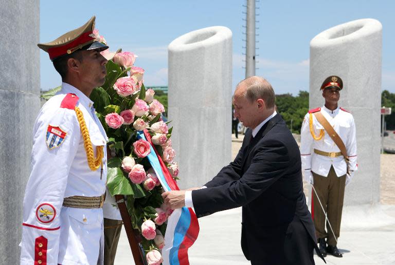 Russian President Vladimir Putin (R) participates in a wreath-laying ceremony at the Jose Marti monument in Revolution Square in Havana, on July 11, 2014