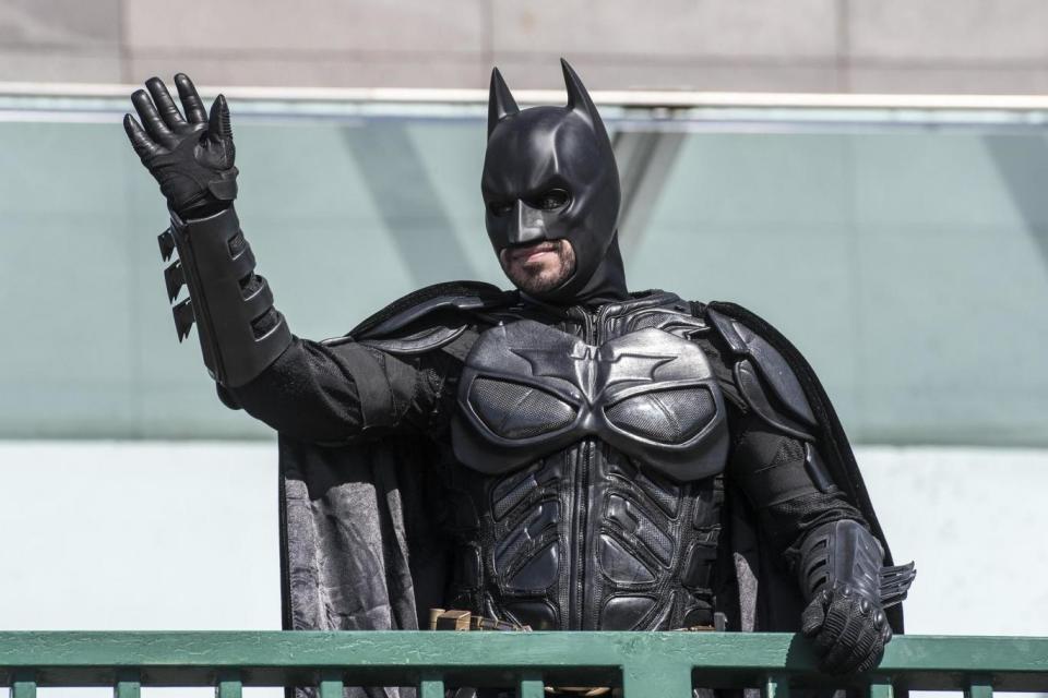 A prankster dressed as Batman tries to steal the limelight at the statue unveiling