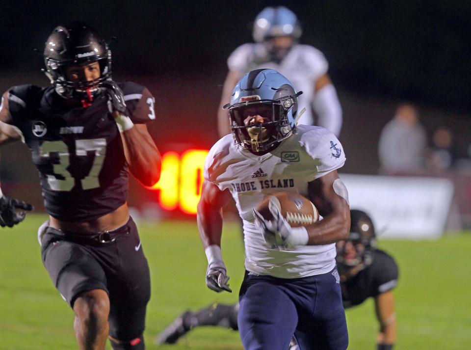 Rhode Island running back Harold Cooper finds a hole off tackle and scampers down the sideline for a first-quarter touchdown in the 2017 Governor's Cup game. Brown's linebacker Isaiah Thompkins is in pursuit.