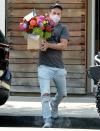 <p>Derek Hough is seen carrying a large arrangement of flowers on Tuesday in L.A.</p>