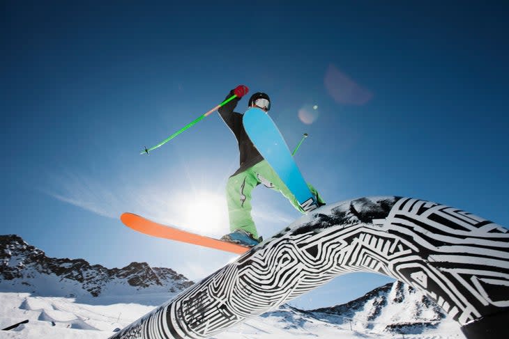 Skier sliding a rail in a terrain park