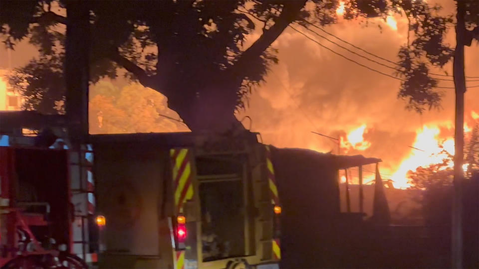 In this image made from video, fire rescue attends to a burning oil depot, in Conakry, Guinea, Monday, Dec. 18, 2023. An explosion and inferno at Guinea’s main fuel depot in the capital of Conakry has left several people dead or injured. Guinea’s presidency says the fire broke out at the Guinean Petroleum Company depot shortly after a massive explosion past midnight Sunday. (AP Photo)