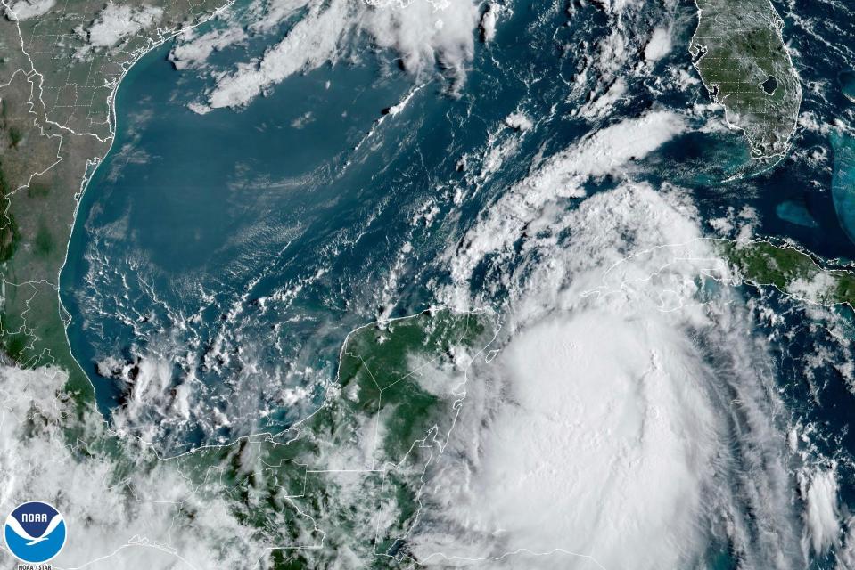 Satellite image provided by the National Oceanic and Atmospheric Administration show tropical Storm Idalia moves between Mexico's Yucatan peninsula, left, and Cuba, right (NOAA via AP)