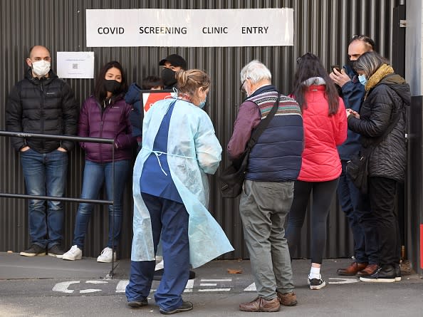 A medical worker speaks to people queueing outside a COVID-19 coronavirus testing venue at The Royal Melbourne Hospital.