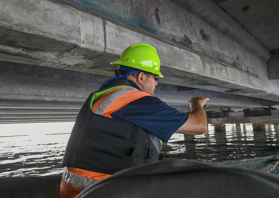 Dennis Burchfield, superintendent for Proshot Concrete, points out the new cement on a span under the Alma Lee Loy Bridge, on Friday, July 16, 2021, in Vero Beach. The new cement placed by Proshot Concrete encases the repairs made to corroded areas of the bridge spans.