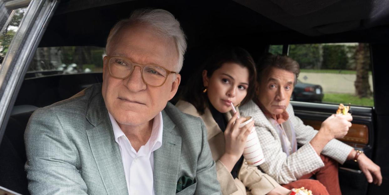 steve martin as charles, selena gomez as mabel, martin short as oliver, sitting in the back of a car together in a scene from only murders in the building season 4 episode 1