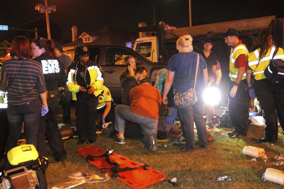 New Orleans emergency personnel attend to injured parade watchers after a pickup truck plowed into a crowd and injured multiple people watching the Krewe of Endymion parade in the Mid-City section of New Orleans, Saturday, Feb. 25, 2017. Police Chief Michael Harrison says one person in custody and that he is being investigated for driving while intoxicated. (Scott Threlkeld/The Advocate via AP)