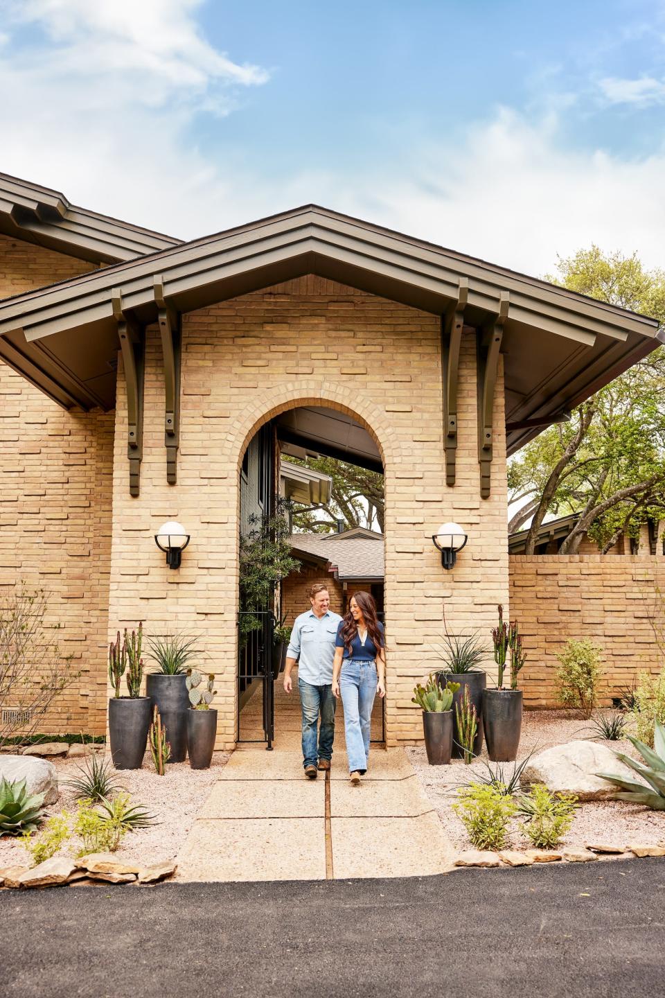 Chip and Joanna Gaines walk through the entrance to a lake house.