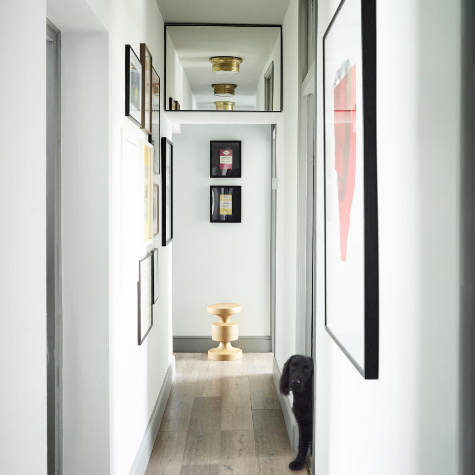 Narrow hallway with mirrors and pictures