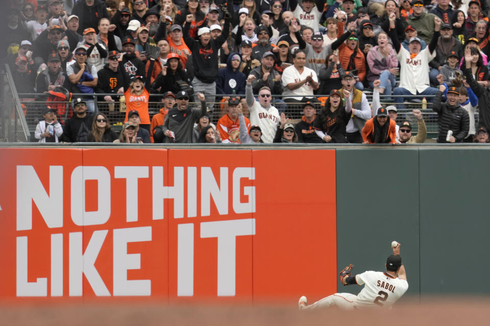 Fans cheer after San Francisco Giants left fielder Blake Sabol (2) caught a fly ball hit by Kansas City Royals' Nicky Lopez during the fourth inning of a baseball game in San Francisco, Friday, April 7, 2023. (AP Photo/Eric Risberg)