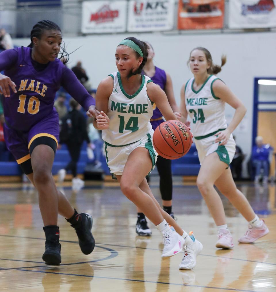 Meade County's Mattie Clanton (14) drives against Male's MaKiya West (10) during the Girls LIT at the Valley High School gym in Louisville, Ky. on Jan. 24, 2023.